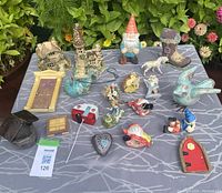 All items laid out on table showing variety of fairy garden decor pieces including houses, figurines, and miniature doors and windows