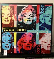 Front view of a 40x40 inch square canvas print showing six multicolored Marilyn Monroe portraits in pop art style, framed in thin black wood.