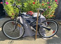 Side profile of Mayhem Infinity mountain bike with knobby tires and helmet resting on the table behind the bike.
