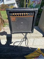 Front view of the Roland DAC 15 guitar amplifier showing control knobs and speaker grille.