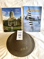 Top view of British WWII air raid helmet marked ARP with two Imperial War Museum books behind it.