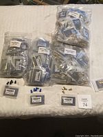 Overview of multiple sealed bags containing various small bike parts including connectors, bolts, and valve caps.
