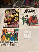 Four comic books displayed on a flat surface: KISS Classics collector's edition, Frank Blof Hard Boiled comic, and two Marvel Comics group 12 cent issues.