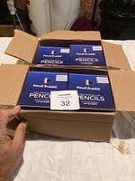 Box containing multiple packs of Pencil Buddies kids triangular pencils, sharpeners and erasers, new in original packaging