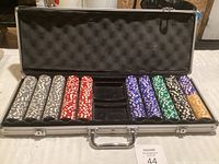 Full view of open aluminum carrying case with poker chip stacks in multiple colors inside.