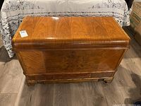 Front view of the cedar chest showing medium brown wood with visible grain and minor surface marks.