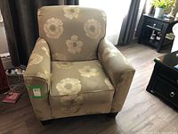 Full front view of the floral upholstered easy chair showing seat, armrests, and cushion.