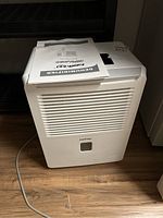 Full view of white KoolKing dehumidifier unit with vents and power cord on wood floor.