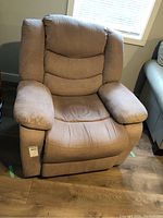 Front view of the brown upholstered electric reclining chair showing cushioned armrests and seat.