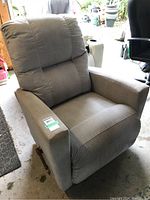 Front and left side view of light grey corduroy recliner with padded cushioned backrest and armrests, showing fabric texture and condition.