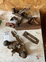 Lot of four vintage metal hand planes with separate parts on a workbench