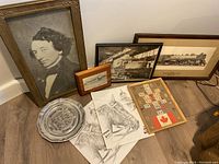 Overview photo showing large framed portrait, locomotive print, smaller train photo, loose sketches of horse heads, silver plate, and framed Scrabble board.