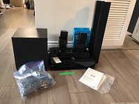 Full wired Sony surround sound system showing subwoofer, central player, 6 speakers and cables on floor