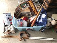 Full view of the sport lot showing the bucket with softballs, baseball bat, horseshoes, Redskins helmet, car flag, Bubba keg, and baseballs.
