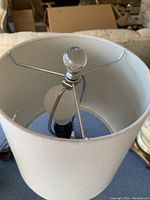 Photo looking down into one of the lamp shades showing the bulb and finial