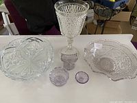 Photo showing all six items: tall vase, crystal footed bowl, and four small lavender glass pieces.