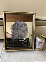 Framed owl mirrored art piece showing glitter accents on owl features and reflection in mirror.