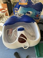 Close-up of blue and white Dr. Scholl's heated water foot spa with roller and box in background