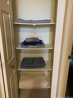 Front view of shelving with folded bedding linens showing different patterns and colors