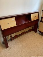 Front view of vintage double size headboard with light wood panel compartments