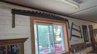 Long two-man steel crosscut saw hanging above window