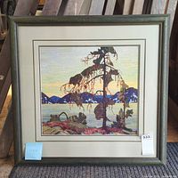 Full view of the framed print showing the entire artwork, the frame, and matting. The print depicts a scenic landscape with a large unique tree in the foreground and distant mountains under a soft sky.