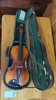 Violin and two bows in open green-felt lined hard case