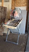 Front view of MK 101 tile saw on folding stand with water tray