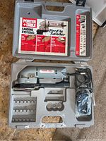 Porter Cable Profile Sander PA66-M35 in gray plastic carrying case with accessories and sanding materials.