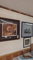 Three framed wildlife prints hung on wall showing fox, ducks, and wolves.