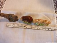 Top view of three ceramic Wade Whoppas figures (wolf, hedgehog, tiger) with measuring scale showing each around 6 cm long.