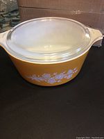 Yellow Butterfly Gold pattern casserole dish with clear glass lid on top, showing the full assembled casserole.