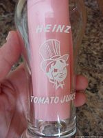 Front side of glass showing Heinz logo with character in top hat and 'Tomato Juice' text