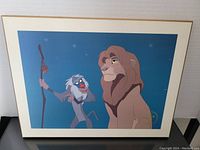 Photo showing the full Lion King lithograph with Rafiki and Mufasa characters in starry night background, mounted with white matte.