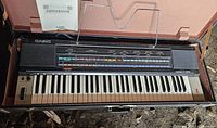 Casiotone 401 keyboard inside original hard case with metal music stand attached