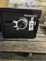 Front view of black Sentry Safe with combination lock dial, keyhole, handle, and brand label visible.