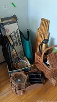 Full lot view showing picnic basket, rackets in box, utility rack box and other items on wooden floor