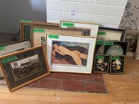 Image showing multiple framed prints including a nude reclining figure in a gold frame, a sepia-toned historical market scene, and other various framed artworks