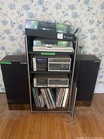 Full setup showing turntable on top, Fisher components on middle shelves, vinyl records below and speakers at sides