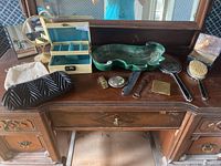 Wide view of lot items on wooden dresser; includes pottery bowl, jewelry box, purses, comb and brush set
