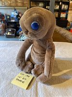 Front view of the 12-inch E.T. plush doll showing blue eyes and soft brown fabric.