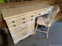 Desk and chair set showing the full front view with drawers and chair positioned next to desk.