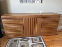 Front view of the oak dresser showing six drawers and middle cupboard with two doors.