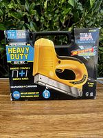 Front side of the Arrow heavy duty electric staple and nail tool in original box showing key features and branding.