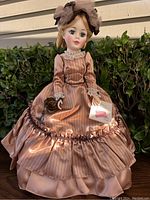 Front view of the Manet Portrait Madame Alexander doll in detailed satin gown outdoors