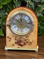 Front view of vintage AT&T Pebble Beach Golf quartz clock with burl wood casing and logo.