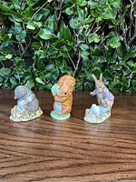 Front view of three porcelain Beatrix Potter figurines, mouse, squirrel, and rabbit.