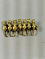 Front view of brooch showing seven kittens seated in a row