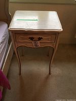 Front view of the white painted solid wood French Provincial night table with one drawer and curved legs.