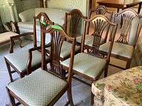Six Hepplewhite style solid mahogany dining chairs with upholstered seats, one armchair and five side chairs, showing the full set in a room.